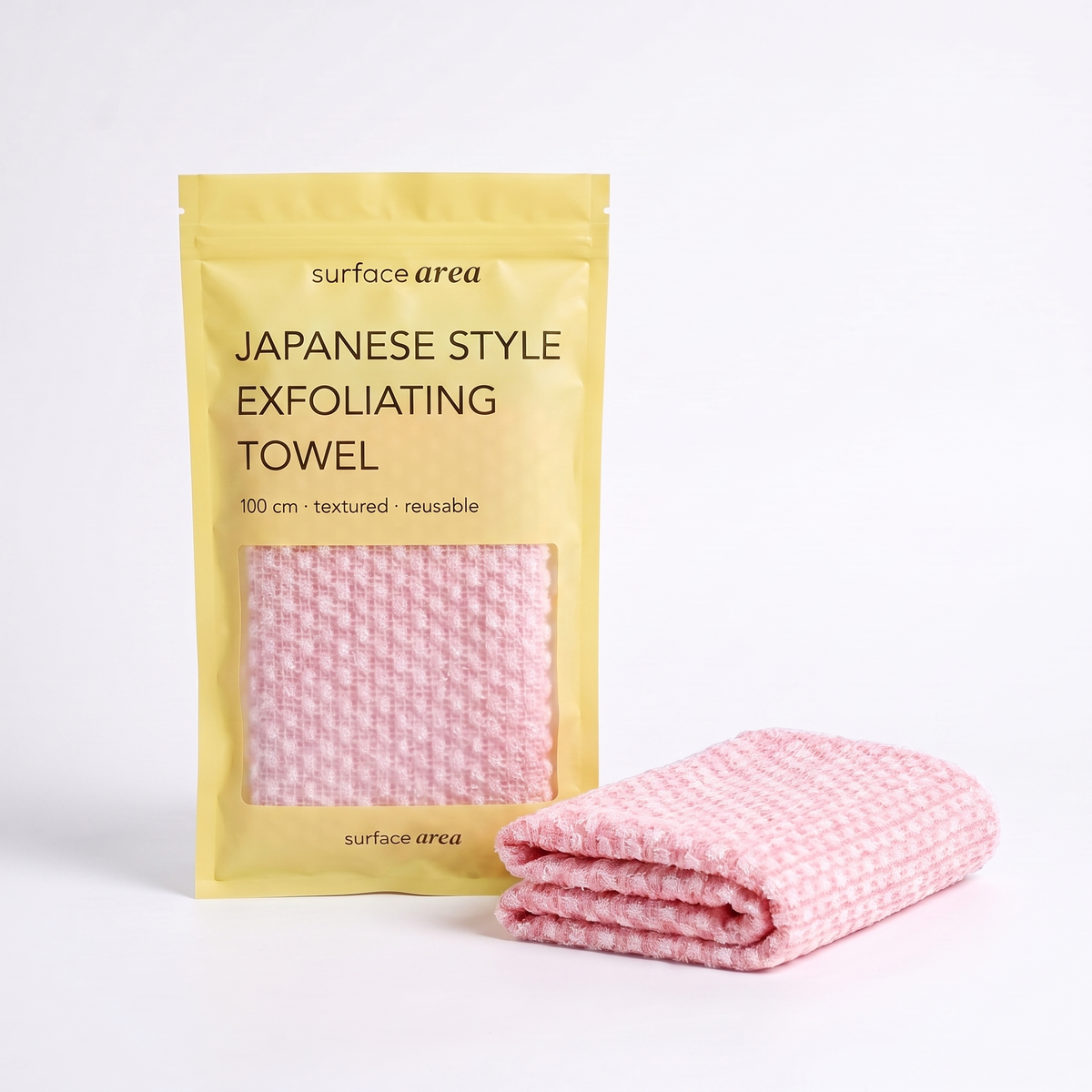 Surface Area Japanese exfoliating towel in Petal Pink with yellow packaging