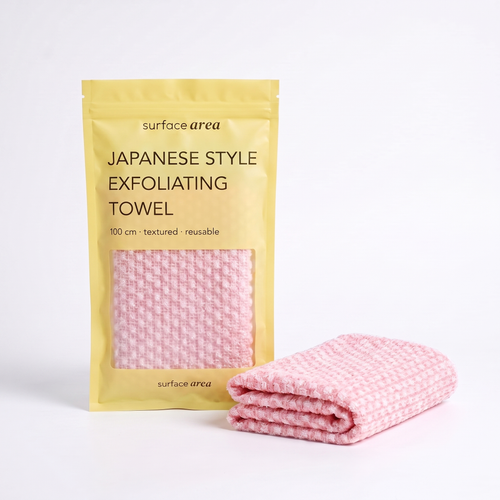 Surface Area Japanese exfoliating towel in Petal Pink with yellow packaging