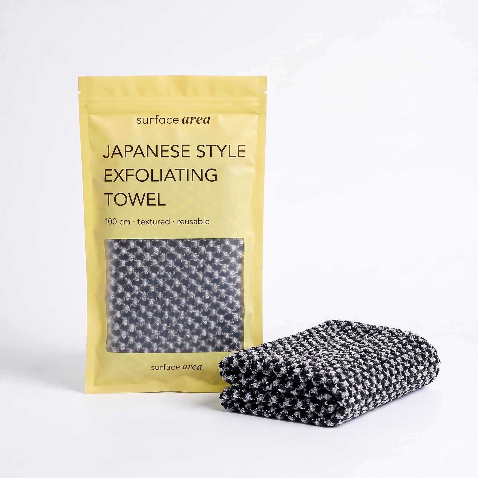 Surface Area Japanese exfoliating towel in Soft Black with yellow packaging